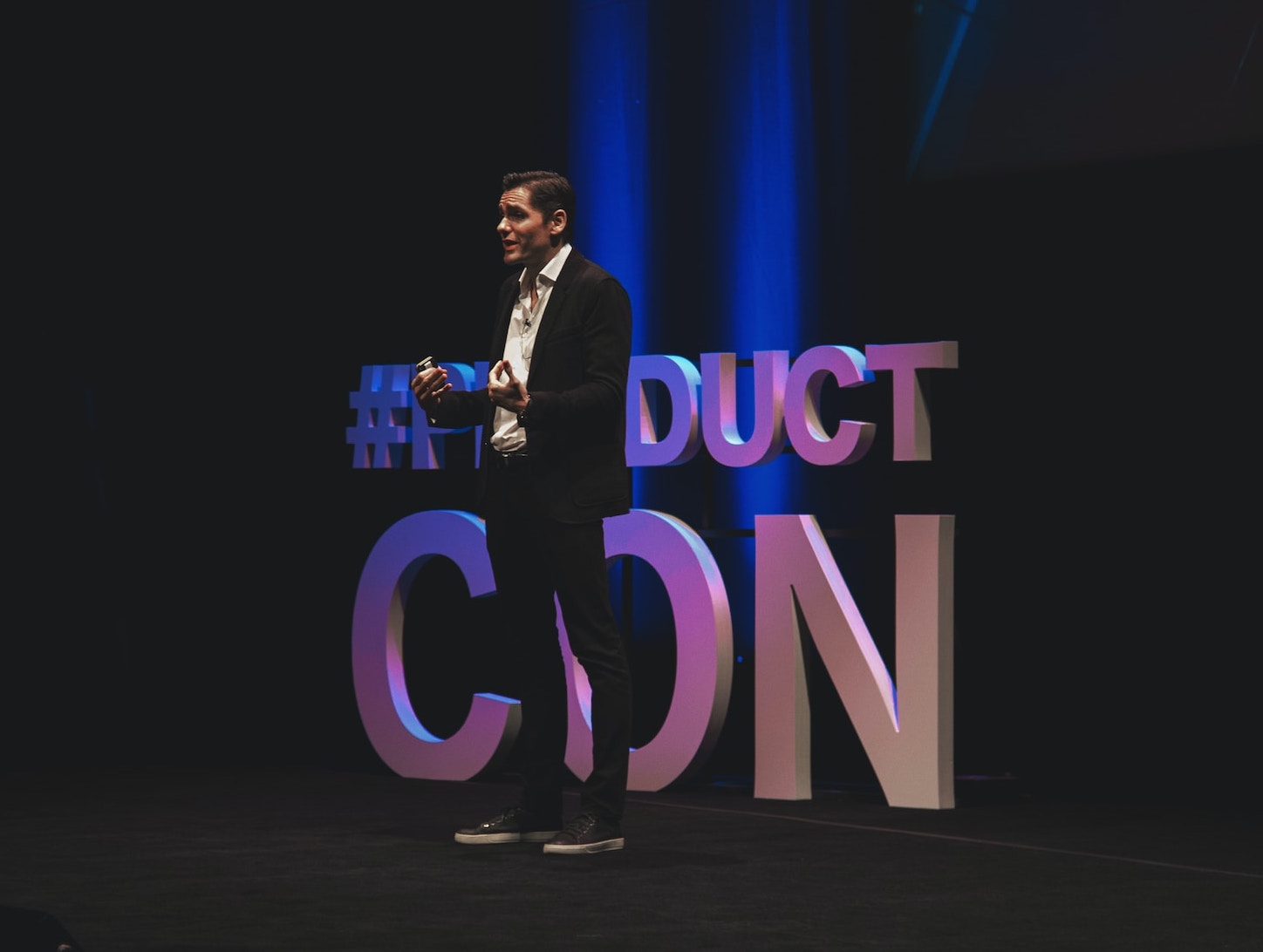 Man in black suit standing on stage